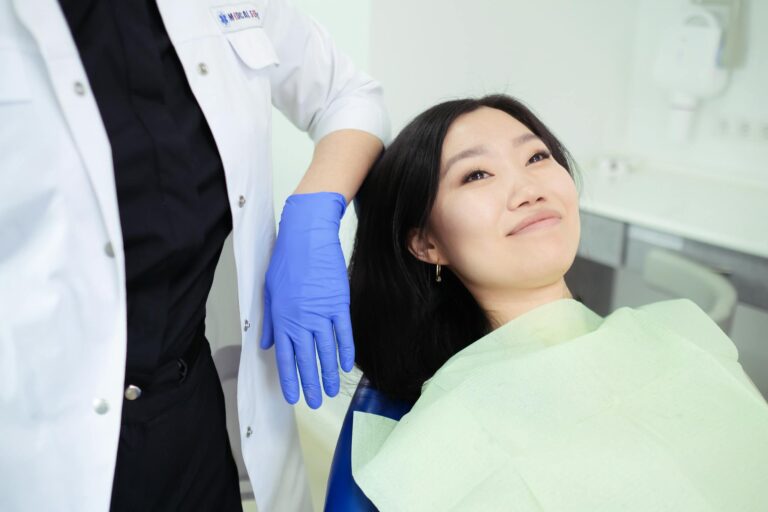 A smiling woman patient during a dental checkup in a modern clinic setting.