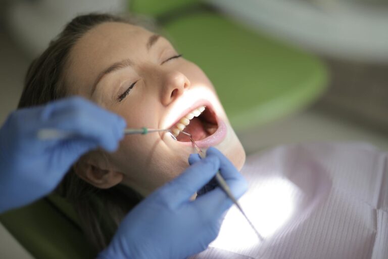 Close-up of a dentist performing a dental check-up on a woman patient in a clinic.