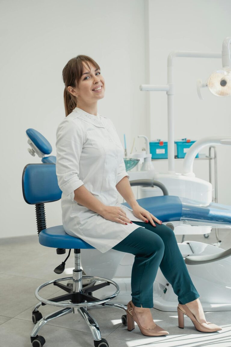 Professional female dentist sitting in a modern, well-equipped dental office.